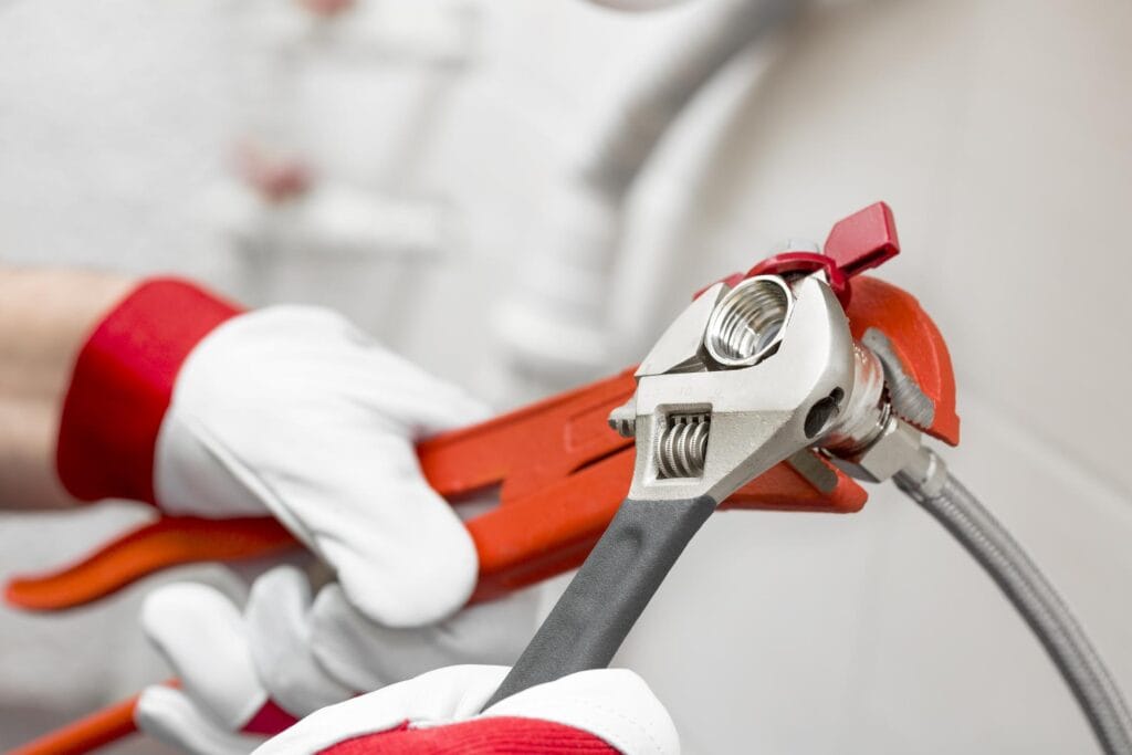 Plumber holding pipe wrenches for an emergency repair in Fort Myers
