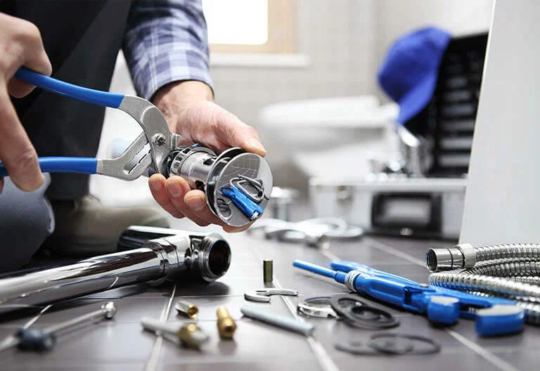 Technician repairing a plumbing fixture with professional tools in Fort Myers