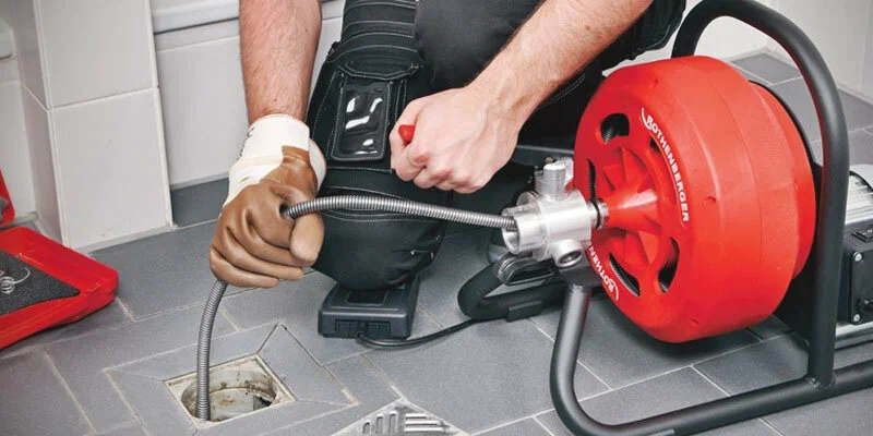 Plumber using a drain-cleaning machine in Fort Myers