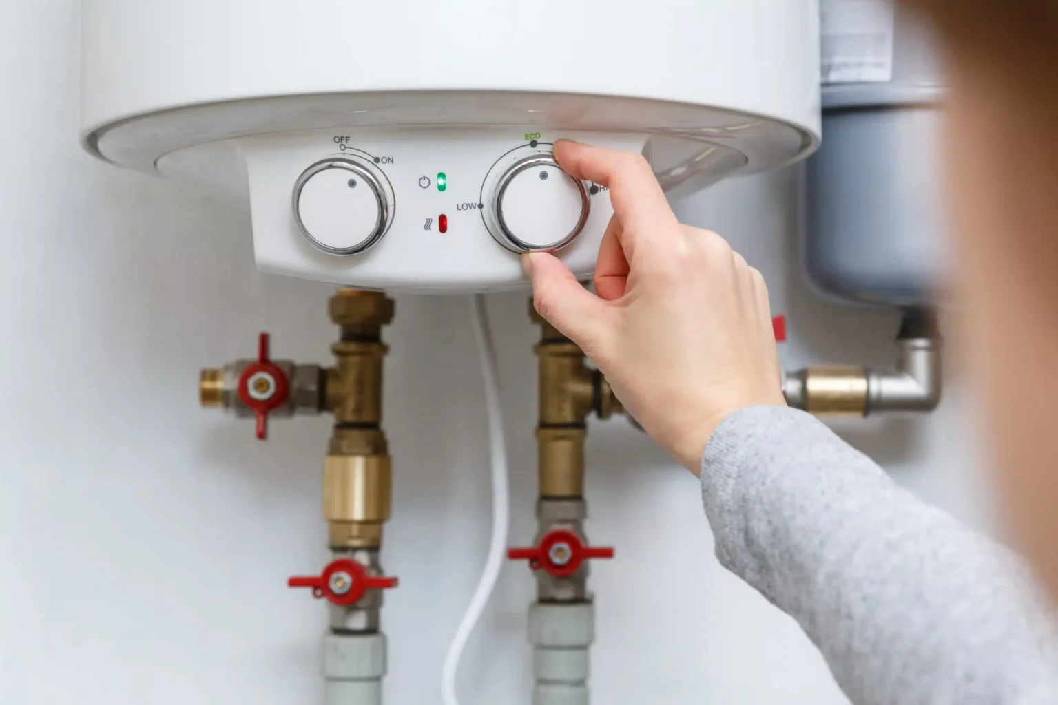 Homeowner adjusting the temperature controls on a water heater in Fort Myers
